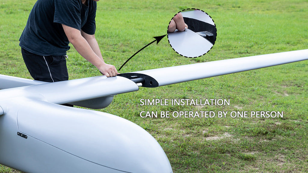 Skyeye 5000mm Carbon fiber fixed wing UAV drone being assembled by one person on a grassy field.