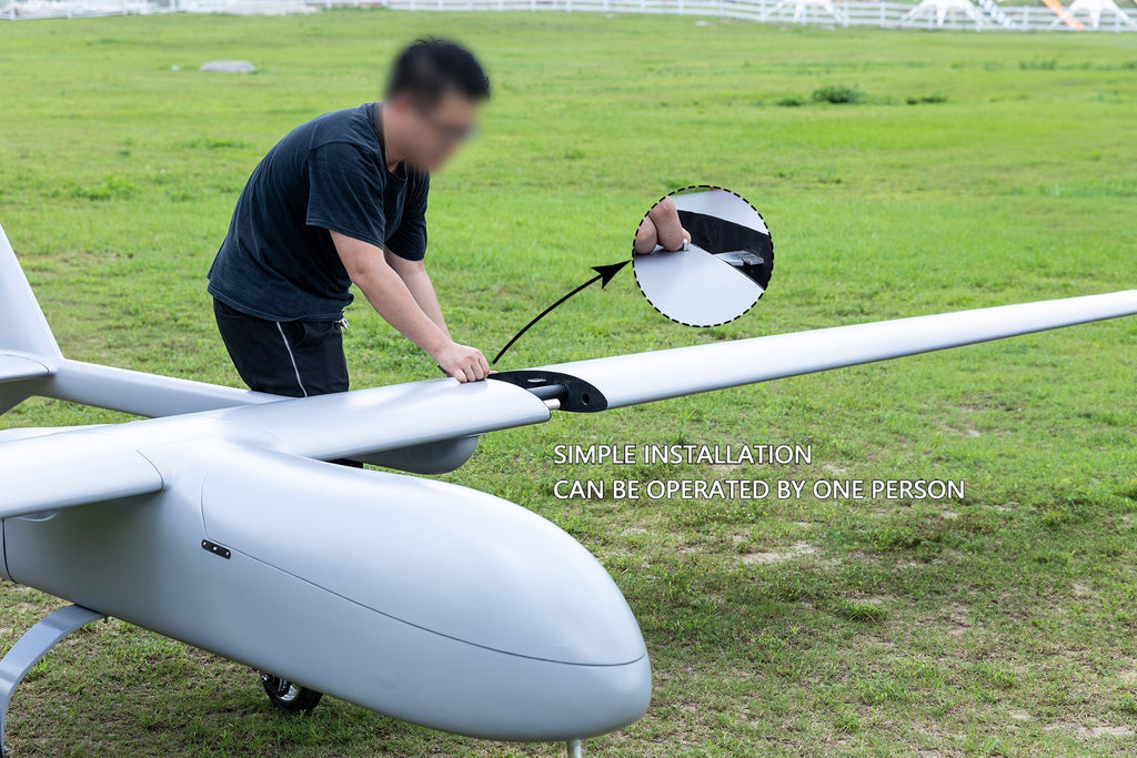 Person demonstrating simple installation of Skyeye Carbon fiber 6000mm UAV Fixed Wing Drone on grass.