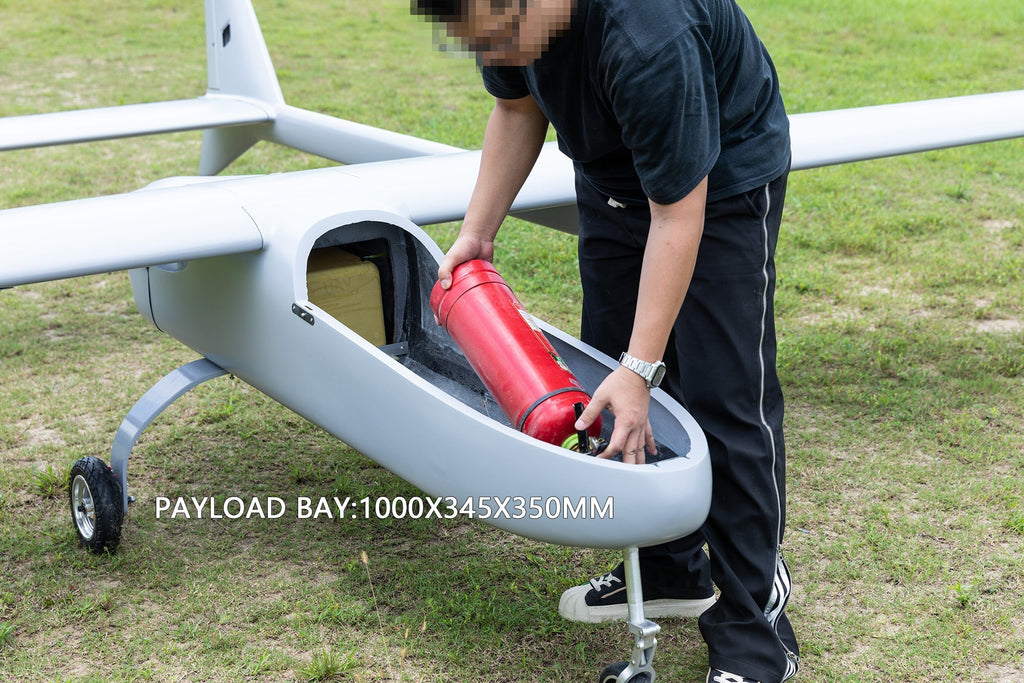Skyeye carbon fiber fixed wing drone with open payload bay (1000x345x350mm) being loaded on grassy field.